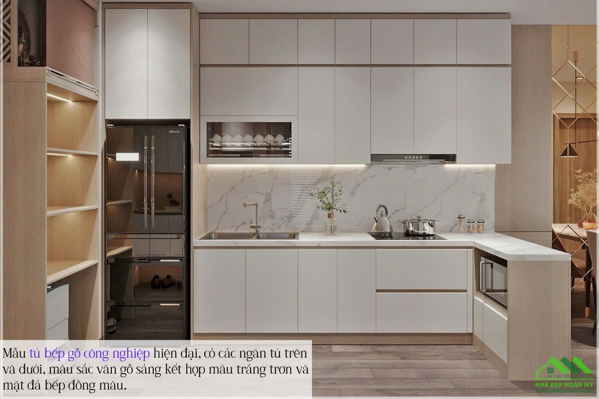Top 5 mẫu tủ bếp chung cư đẹp nhất tại Hải Phòng: "Bật Mí" 5 xu hướng thiết kế đỉnh cao 2026 1 Mẫu tủ bếp chung cư đẹp gỗ công nghiệp hiện đại, có các ngăn tủ trên và dưới, màu sắc vân gỗ sáng kết hợp màu trắng trơn và mặt đá bếp đồng màu.